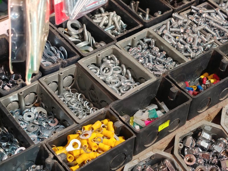 Fasteners and small parts sorted into metal bins